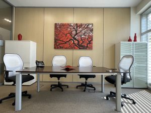 Amplia sala de reuniones privada para cuatro personas en mesa de madera con luz natural, armarios acrista