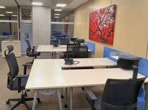 Despacho privado amplio con seis puestos de trabajo y cuadro rojo